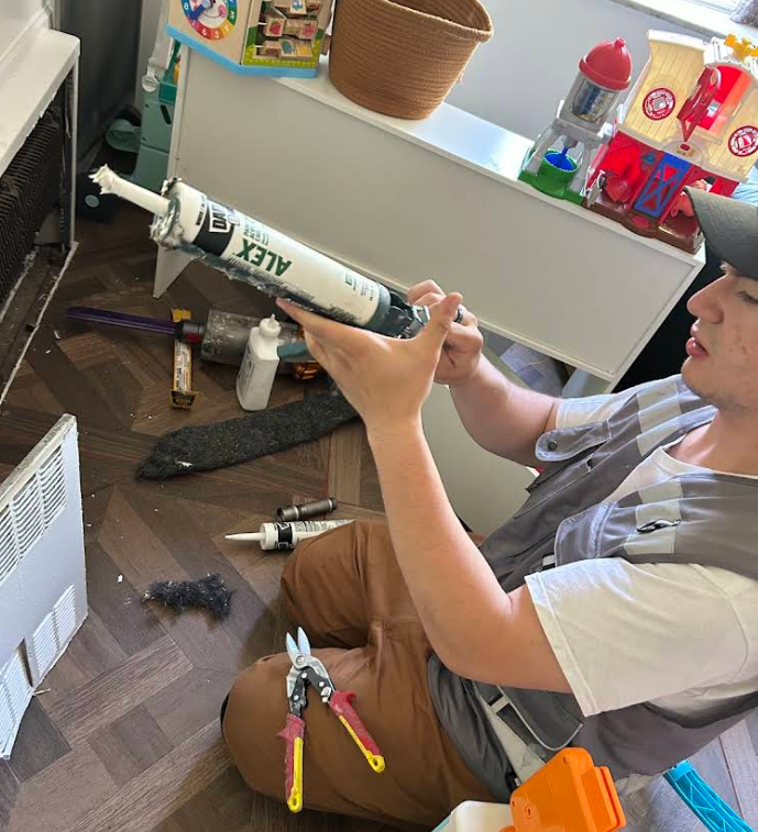 Technician sealing perimeter gaps and cracks in an occupied home, Brooklyn