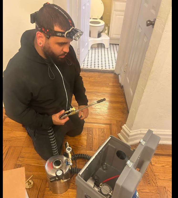 NYE technician setting up bed bug treatment equipment in an NYC apartment