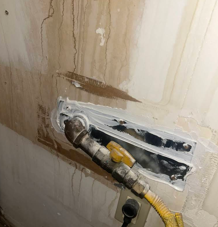 Large gas-line entry point sealed with custom-cut metal and sealant, NYC