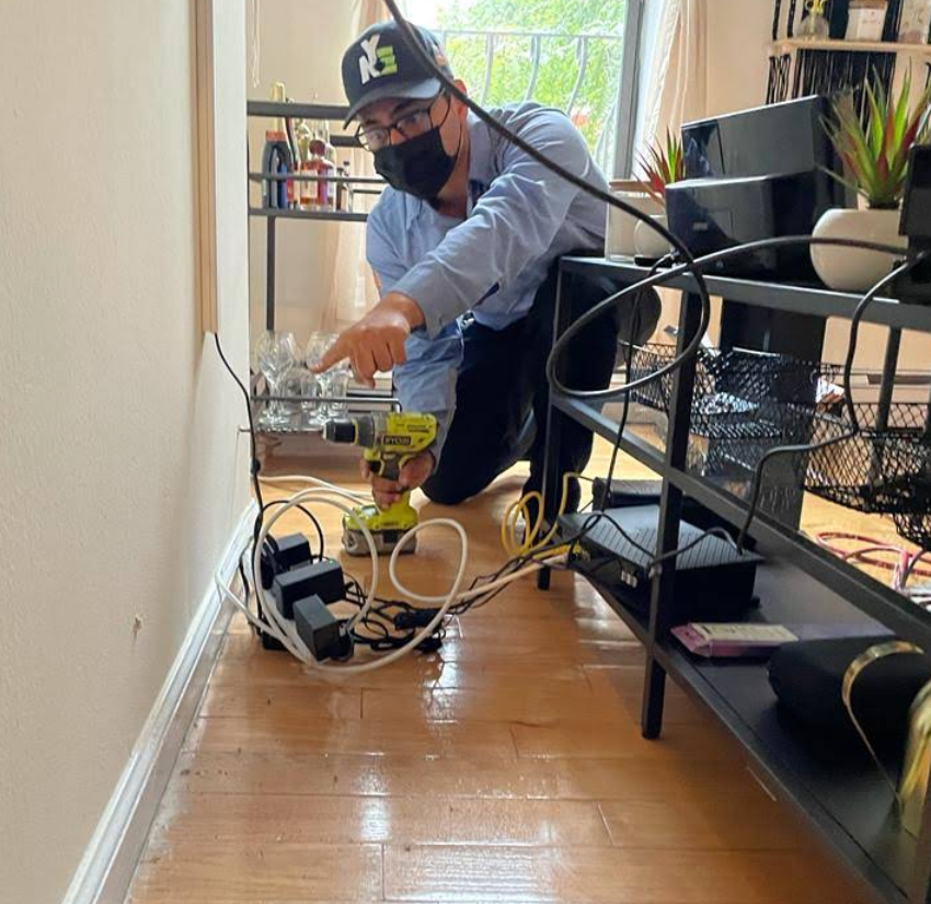 NYE technician injecting treatment into a wall void where pests harbor, NYC