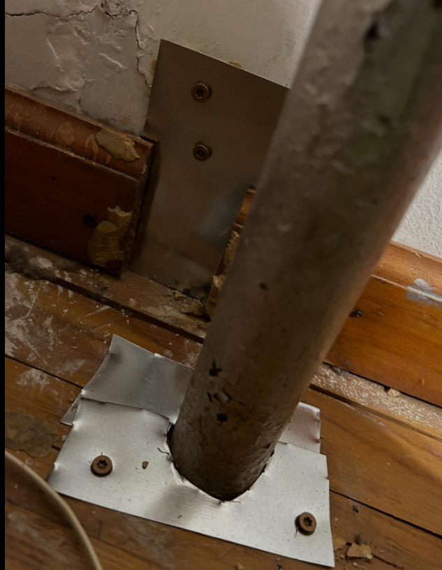 Pipe penetration sealed with a metal plate to block rodents