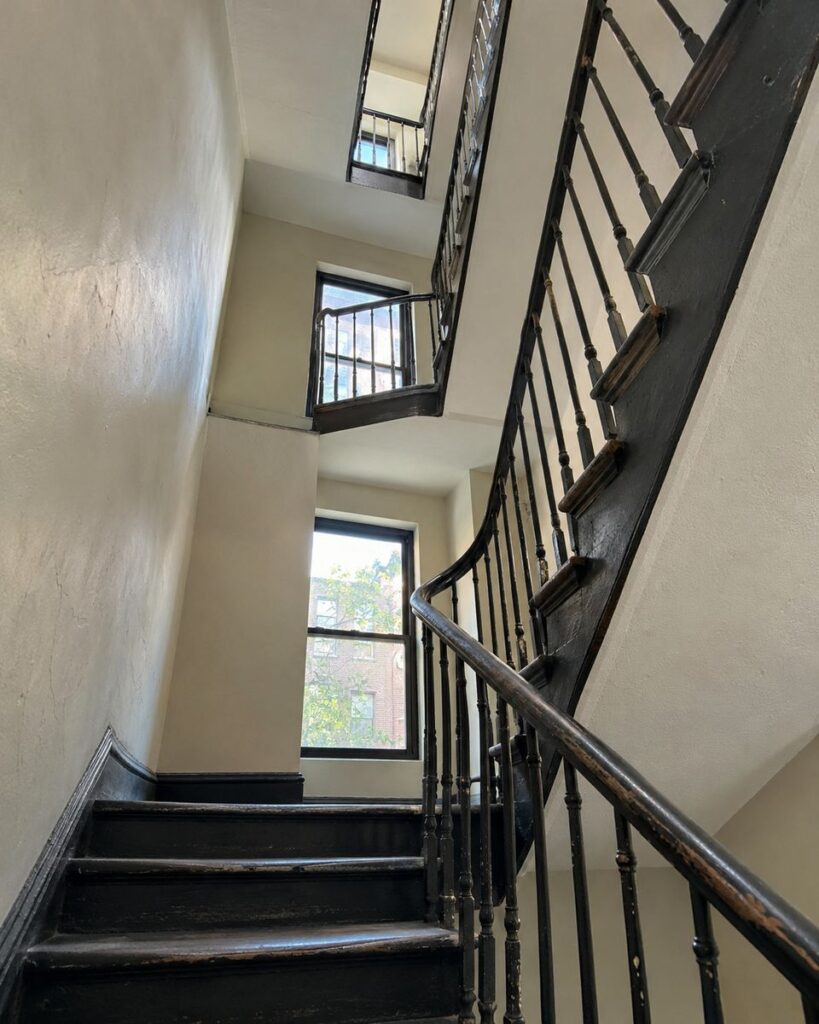 Narrow pre-war NYC walk-up stairwell