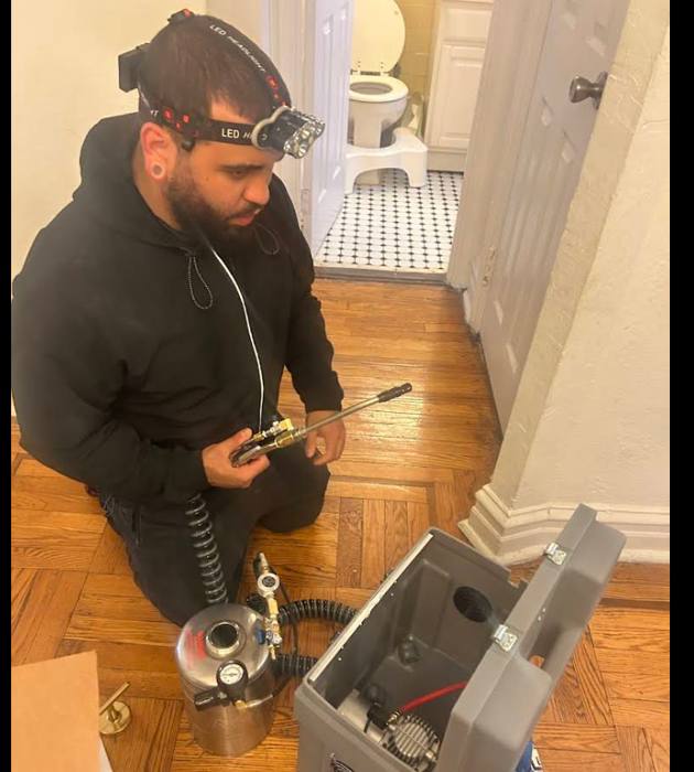 NYE technician with application equipment in an apartment