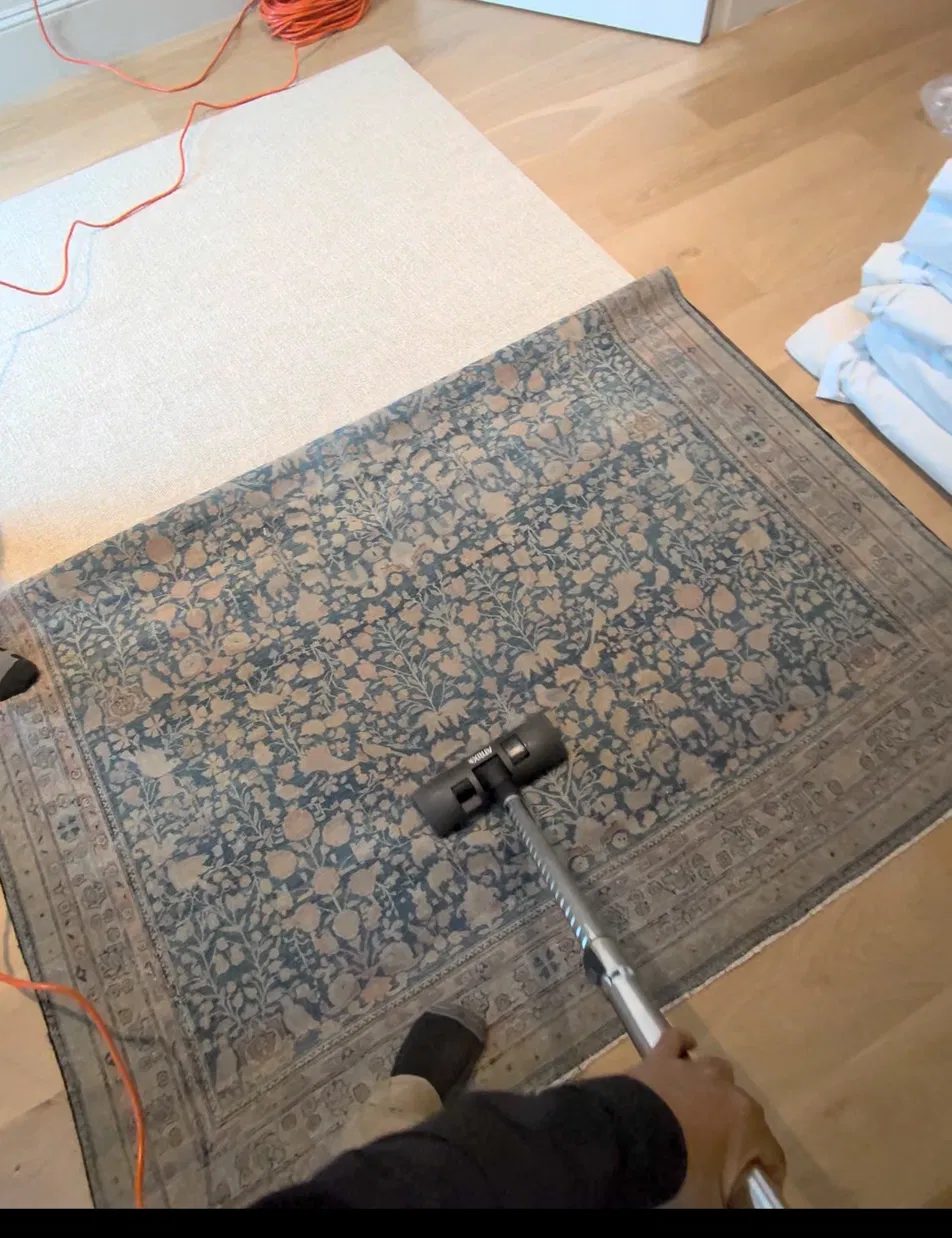 Backpack HEPA vacuum on the back of a wool rug