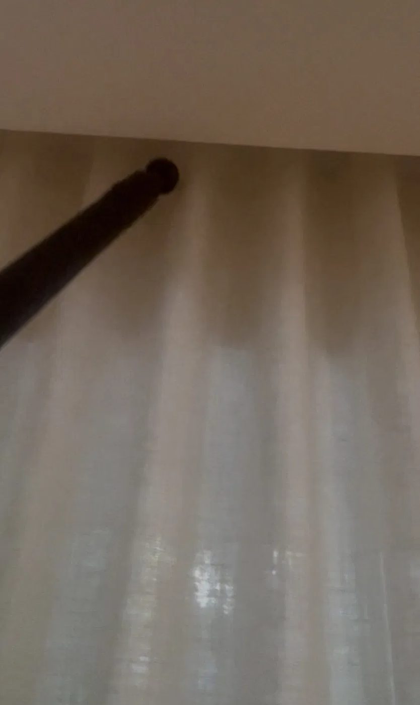 NYE technician steaming the top of a curtain